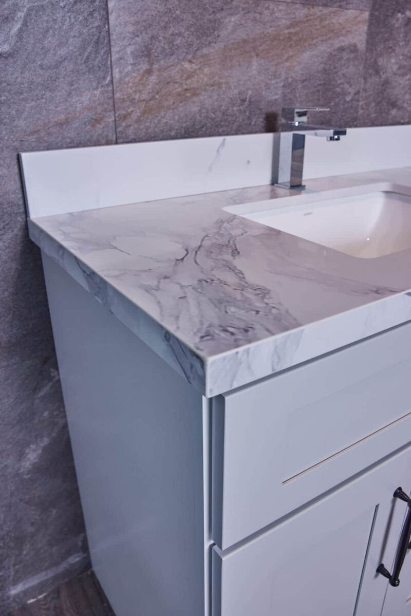 Modern bathroom vanity with marble countertop and sleek faucet.