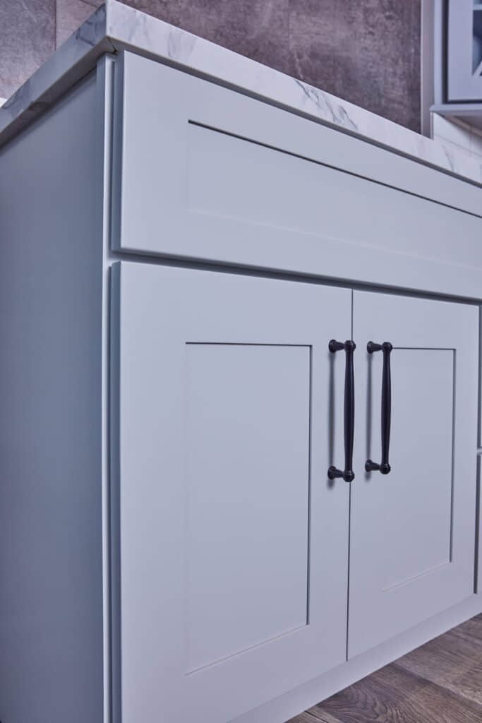 Modern kitchen cabinet with marble countertop and sleek handles.