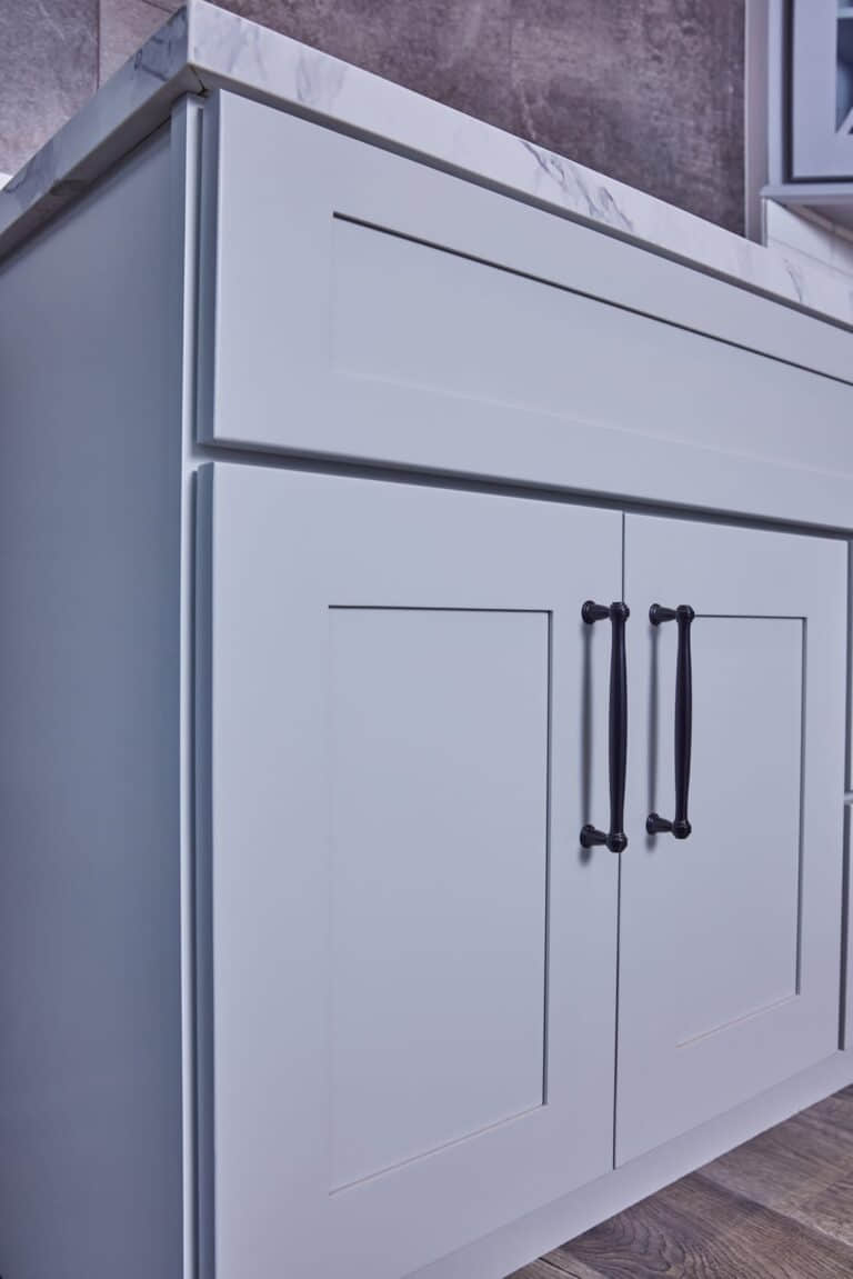 Modern kitchen cabinet with marble countertop and sleek handles.