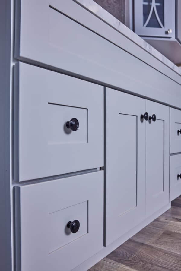 White kitchen cabinets with black knobs.