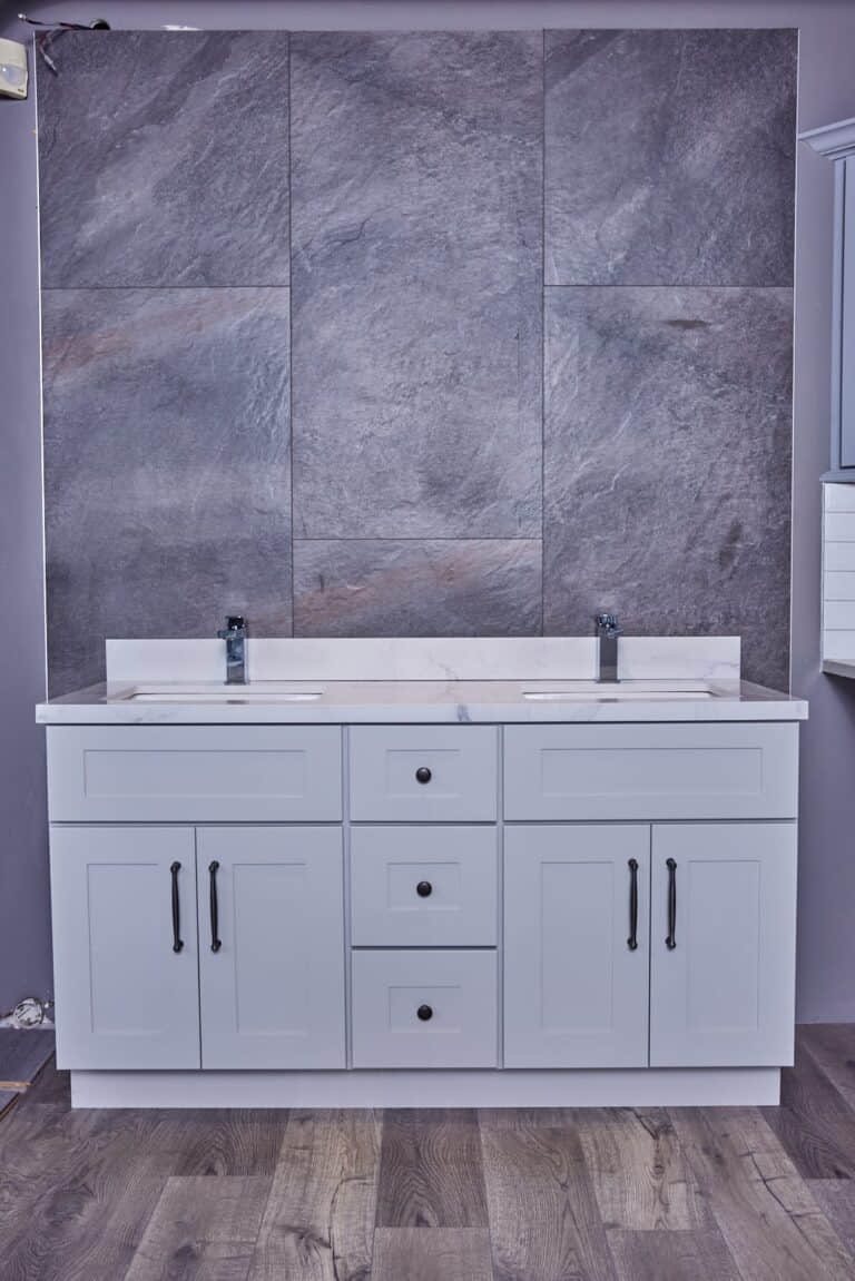 Modern bathroom vanity with dual sinks and gray stone backsplash.