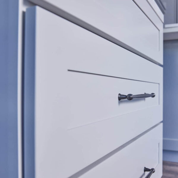 White kitchen cabinet with sleek black handle.