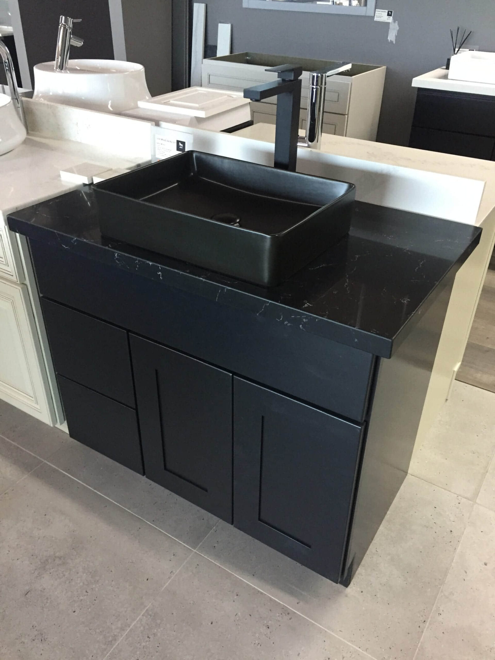 Black bathroom vanity with square sink and modern faucet.