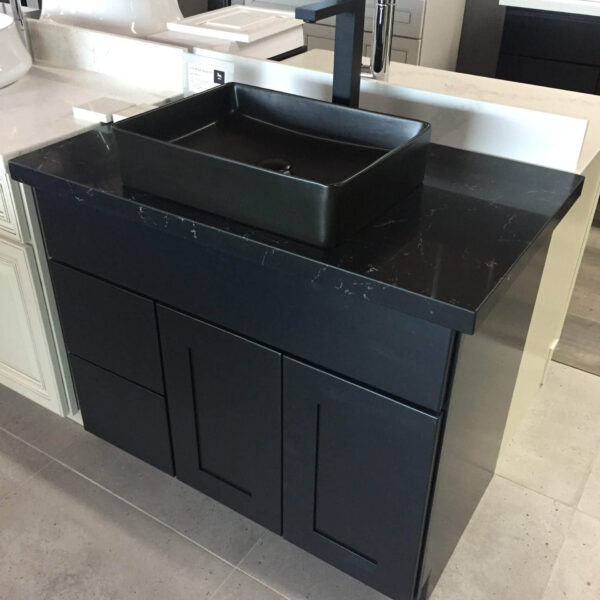 Black bathroom vanity with square sink and modern faucet.