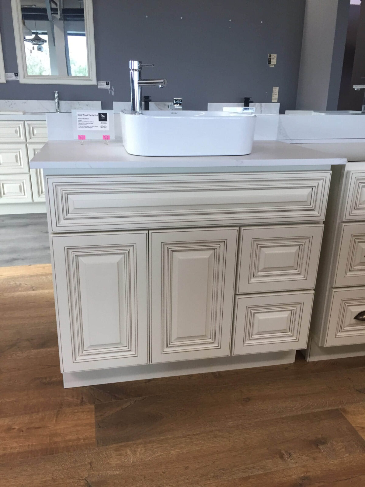 White bathroom vanity with sink on wooden floor.