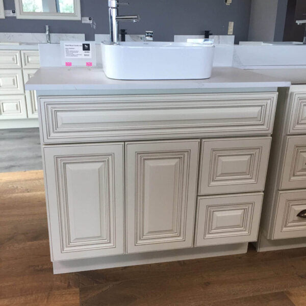 White bathroom vanity with sink on wooden floor.