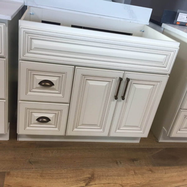 White kitchen cabinets with ornate detailing on a wooden floor.