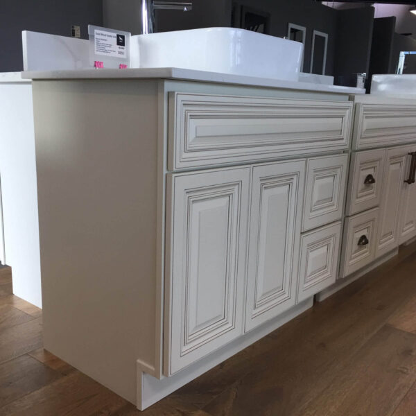 Cream kitchen cabinets with detailed paneling and a white countertop.