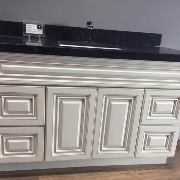 White kitchen cabinet with black countertop and sink.