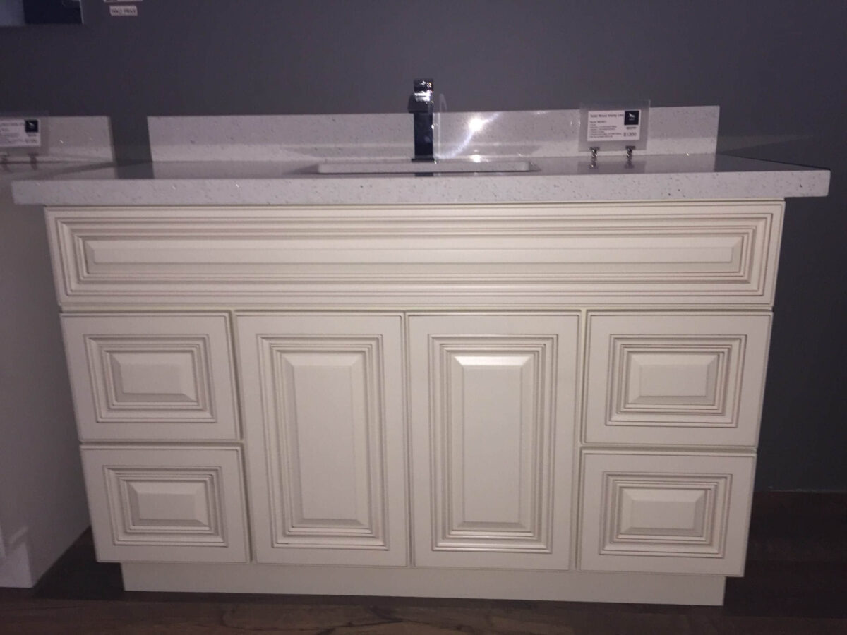 White kitchen cabinet with sink and faucet.