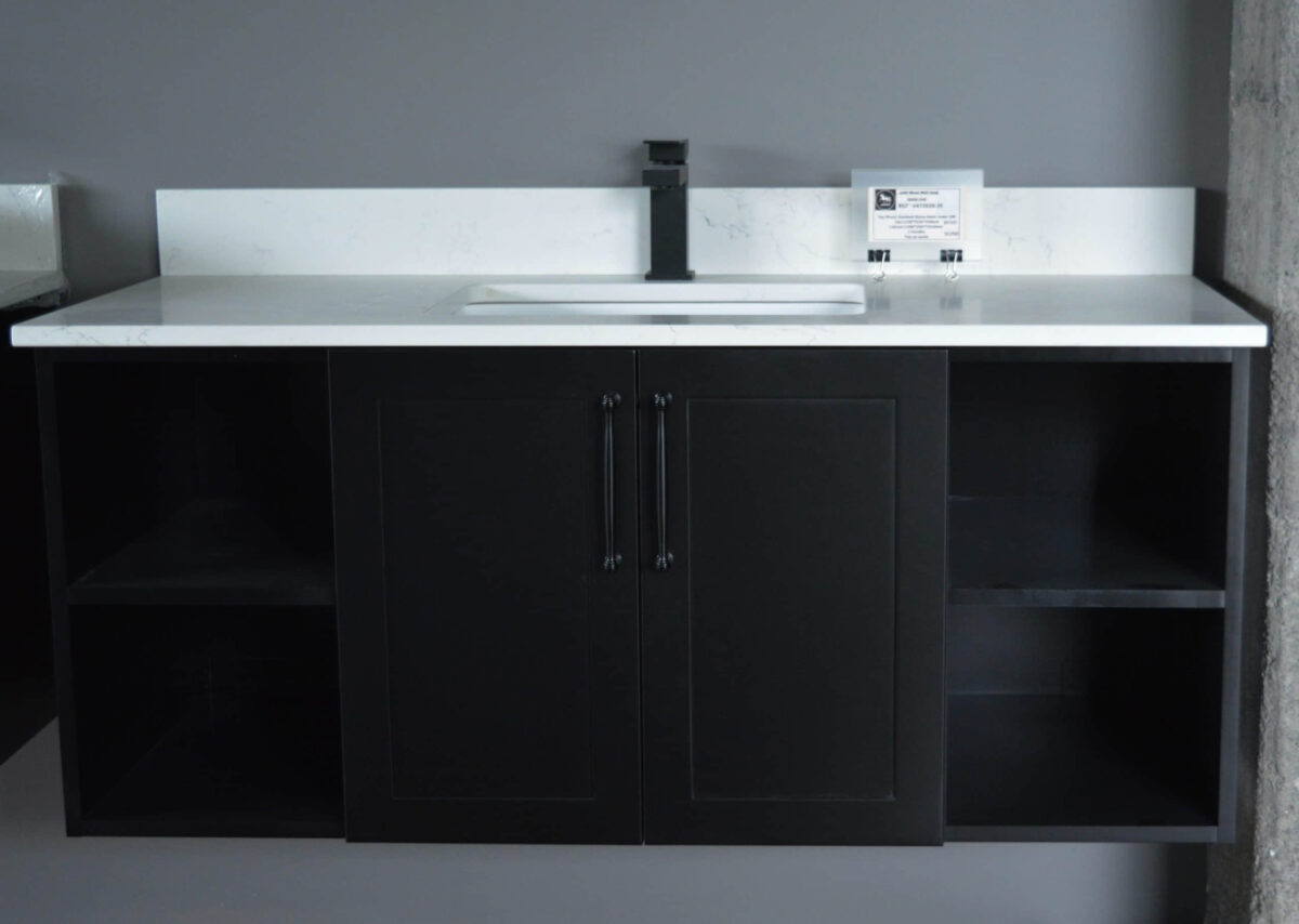 Black kitchen cabinet with white countertop and modern faucet.