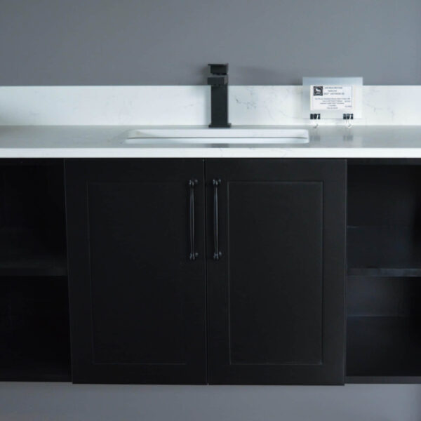 Black kitchen cabinet with white countertop and modern faucet.