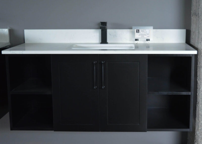 Black kitchen cabinet with white countertop and modern faucet.