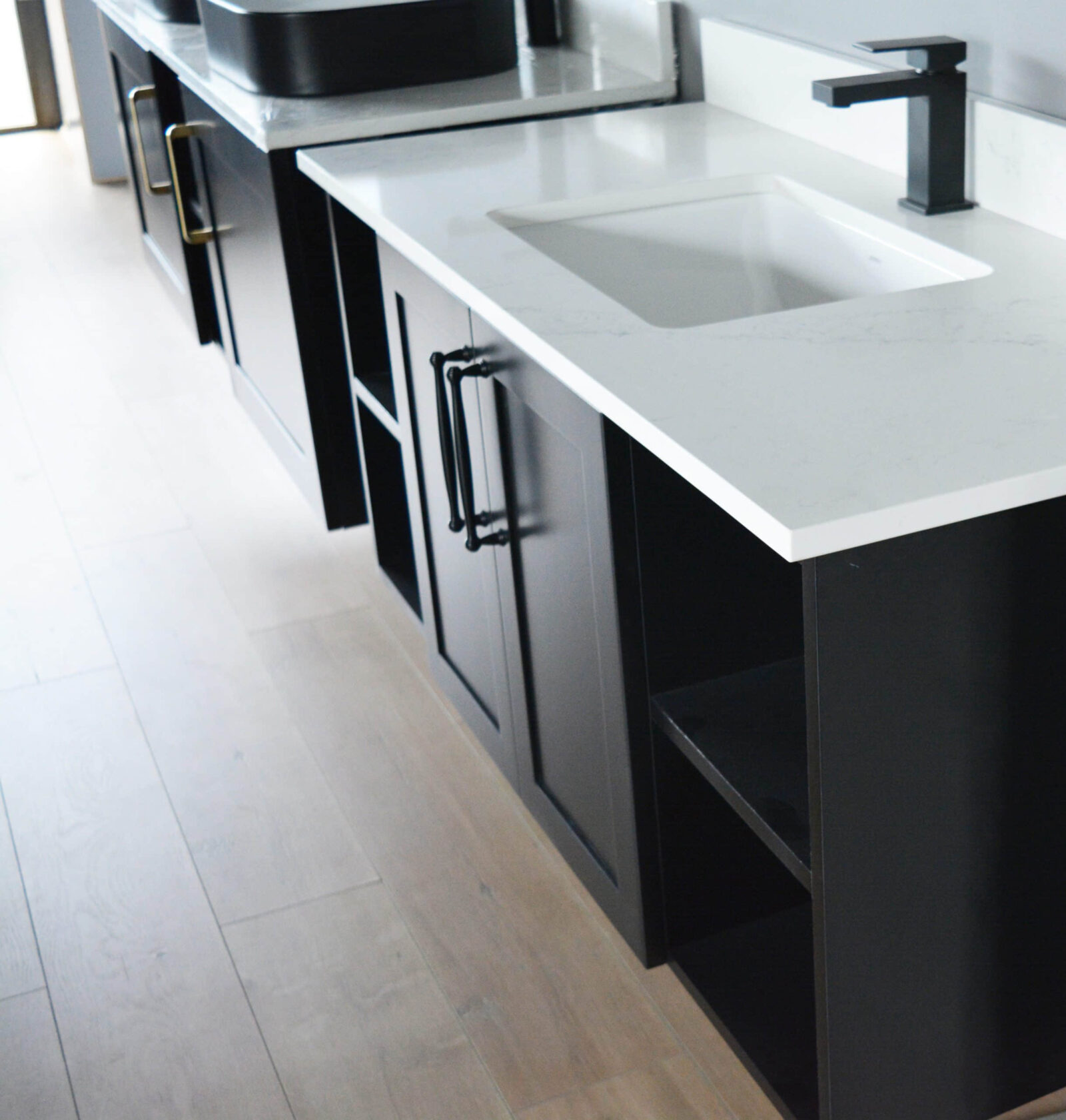 Modern kitchen with black cabinets and white countertops.
