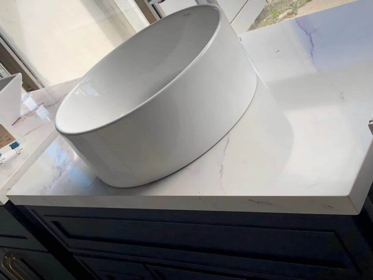 White ceramic sink on marble countertop in modern kitchen.