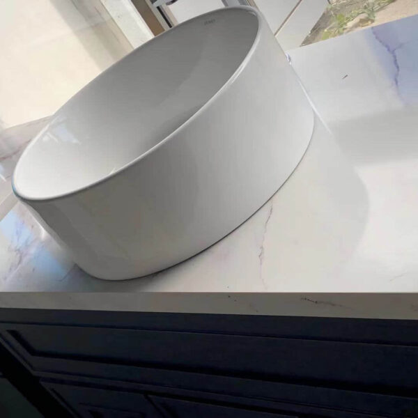 White ceramic sink on marble countertop in modern kitchen.