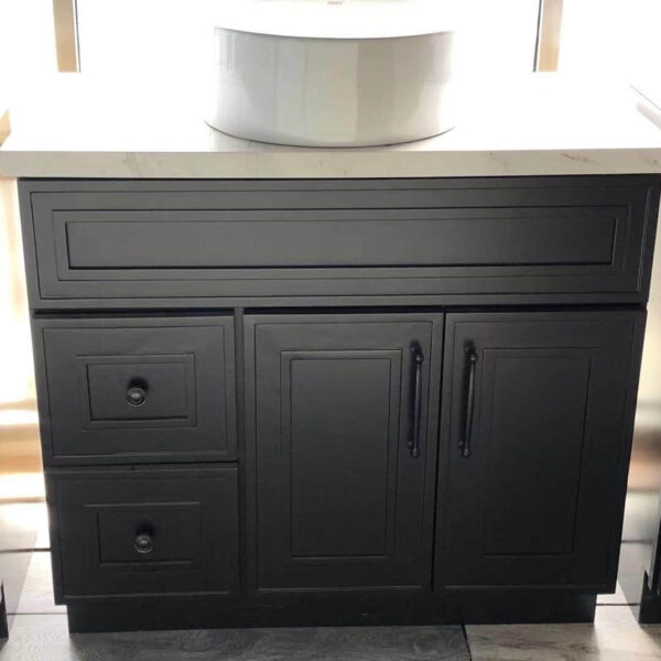 Black kitchen cabinet with drawers and a white countertop.