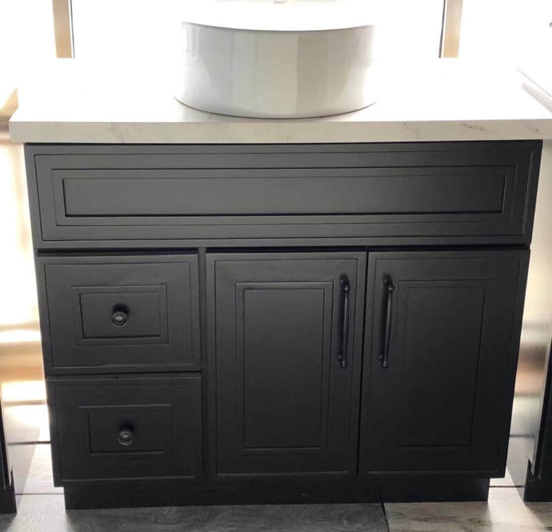 Black kitchen cabinet with drawers and a white countertop.