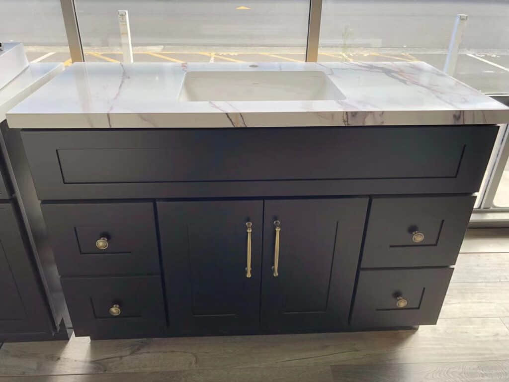 Black bathroom vanity with marble countertop in showroom.