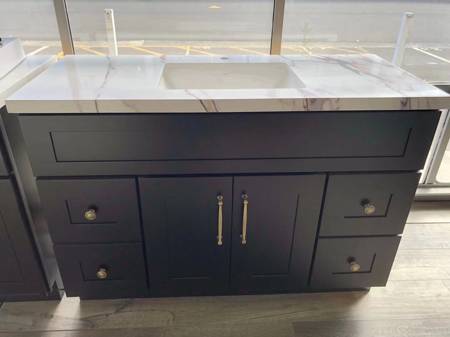 Black bathroom vanity with marble countertop in showroom.