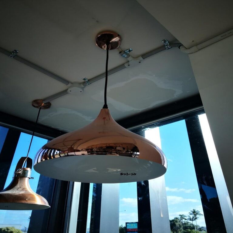 Copper pendant lights hanging from a ceiling in a modern kitchen.