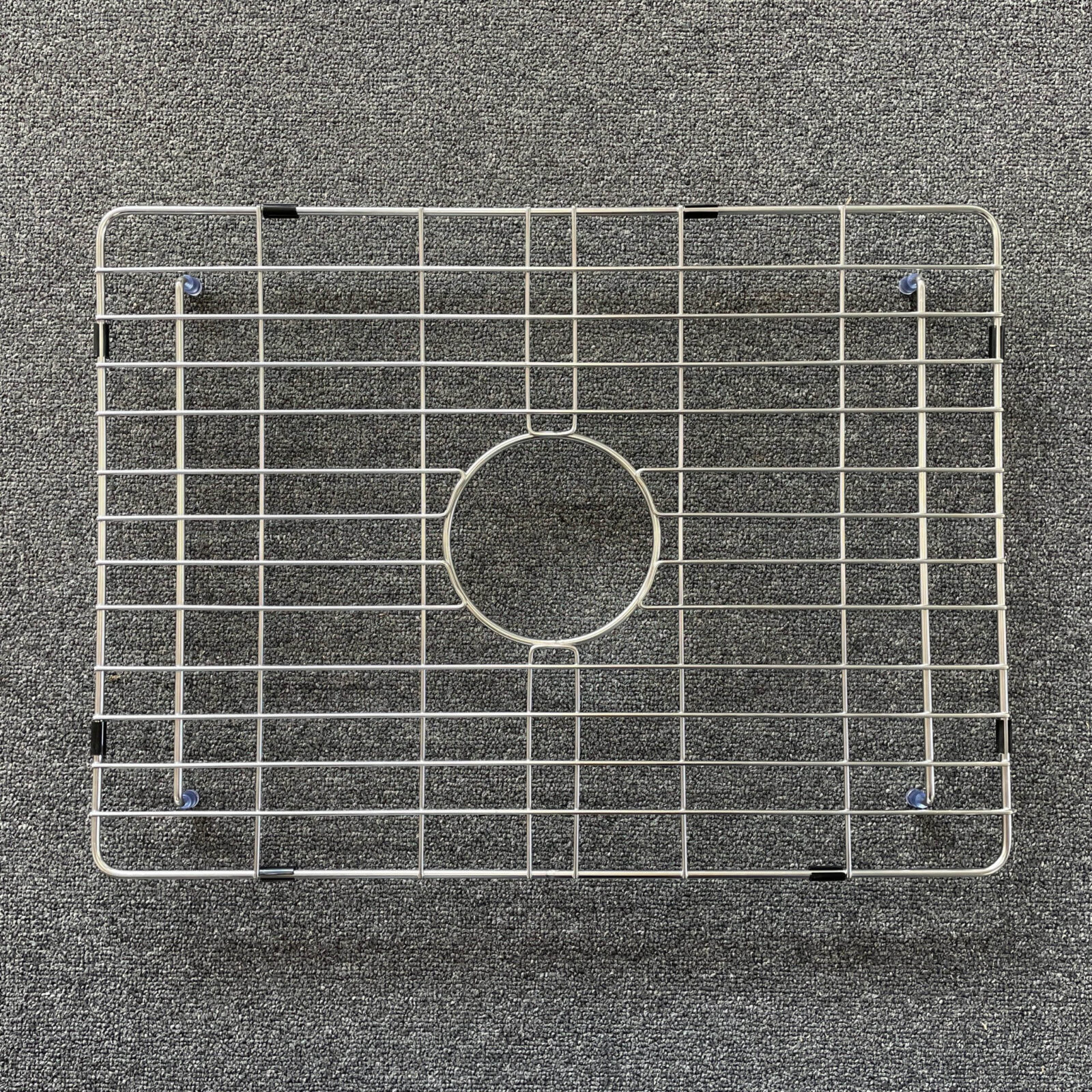 singleS-scaled-1.jpg Stainless steel sink grid on a textured surface.