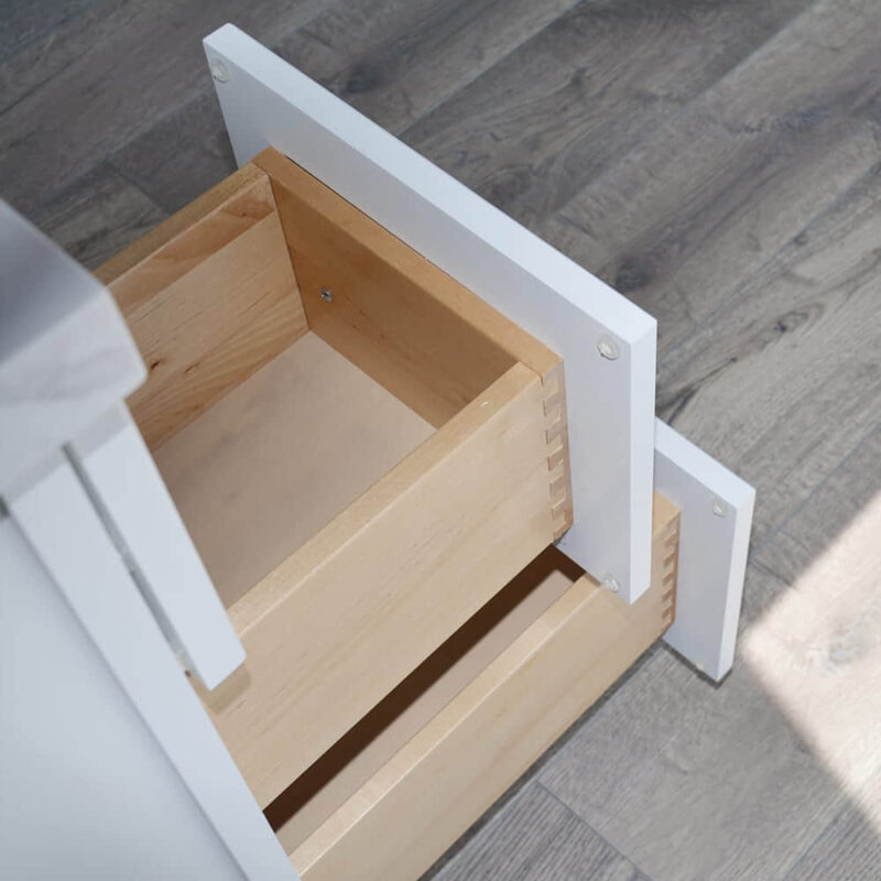 Solid wood drawers on a wooden floor, partially open.