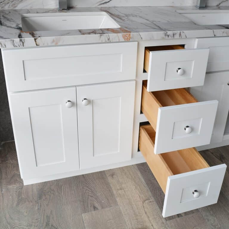 White bathroom vanity with open solid wood drawers.