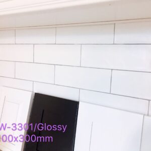 Glossy white subway tiles with black and white cabinet samples.