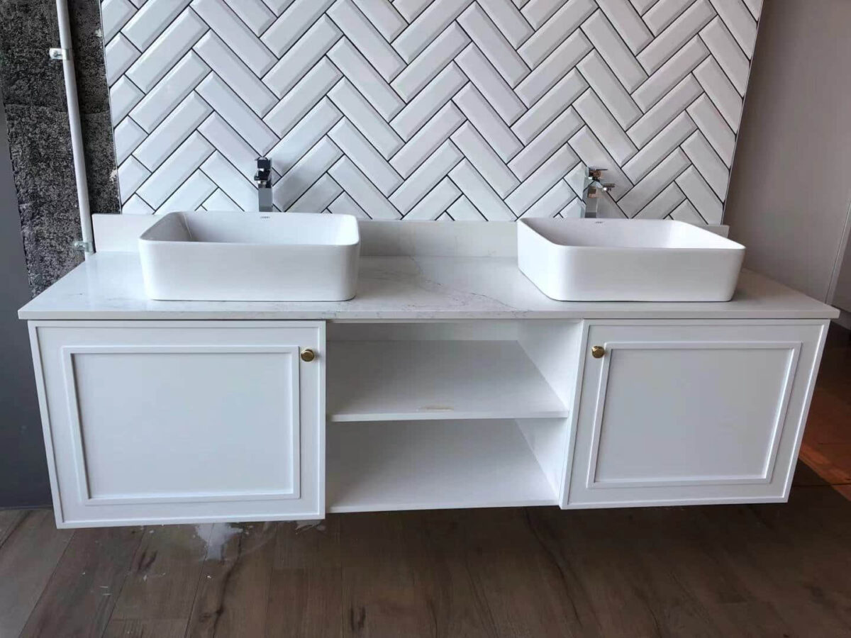 Double sink vanity with herringbone tile backsplash.