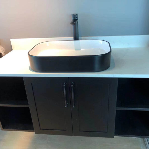 Modern bathroom vanity with black sink and storage cabinets.