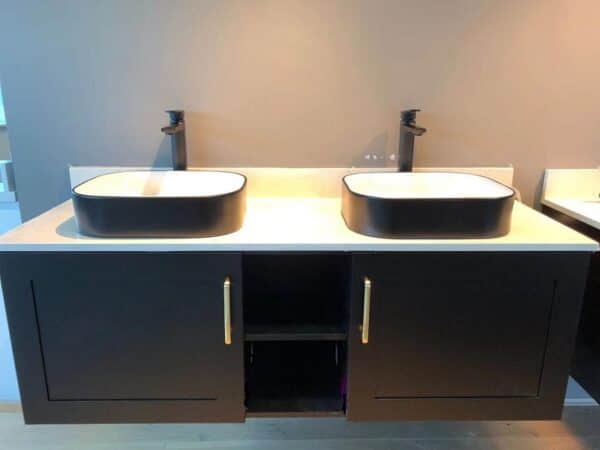 Modern bathroom with double sinks and black cabinetry.
