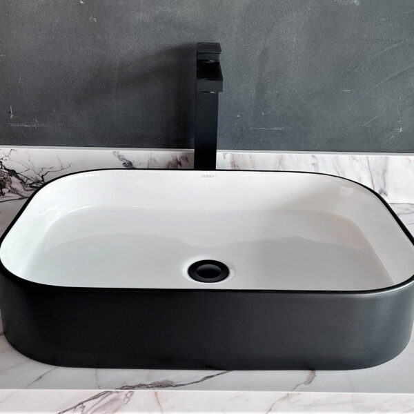 Modern black and white rectangular bathroom sink with marble countertop.