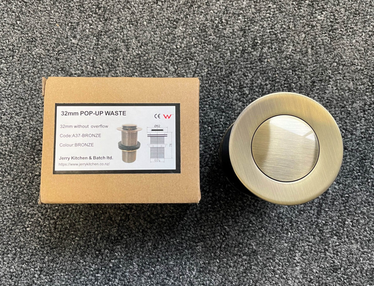 Bronze 32mm pop-up waste with packaging on carpet.