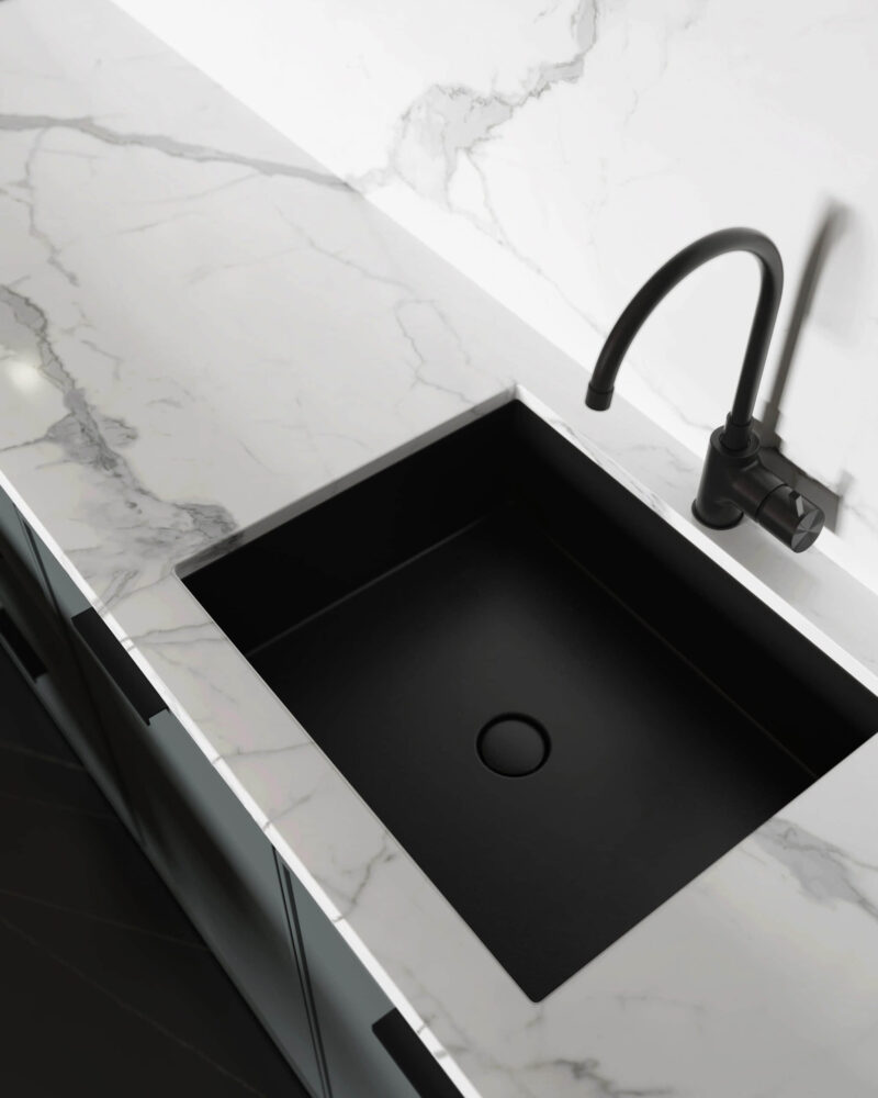 Modern kitchen with black sink and marble countertop.