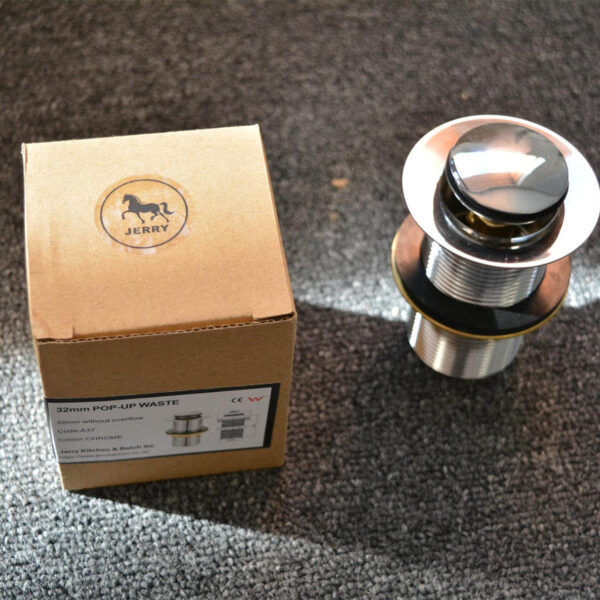 Chrome pop-up waste without overflow next to a cardboard box on carpet.