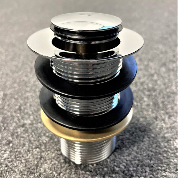 Chrome pop-up waste without overflow on carpeted surface.