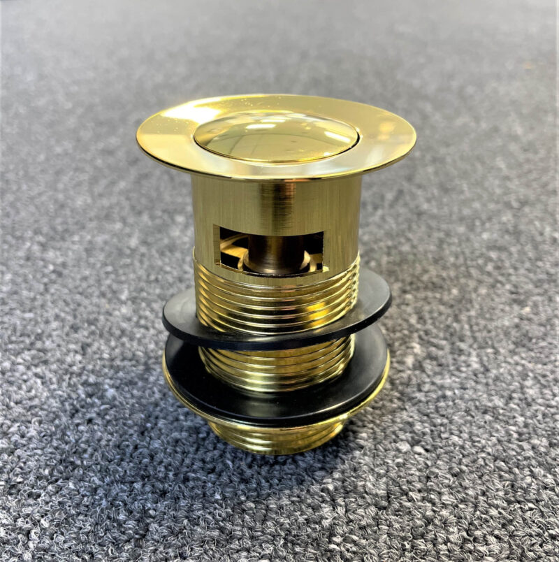 Gold pop-up waste with overflow, top view on gray surface.