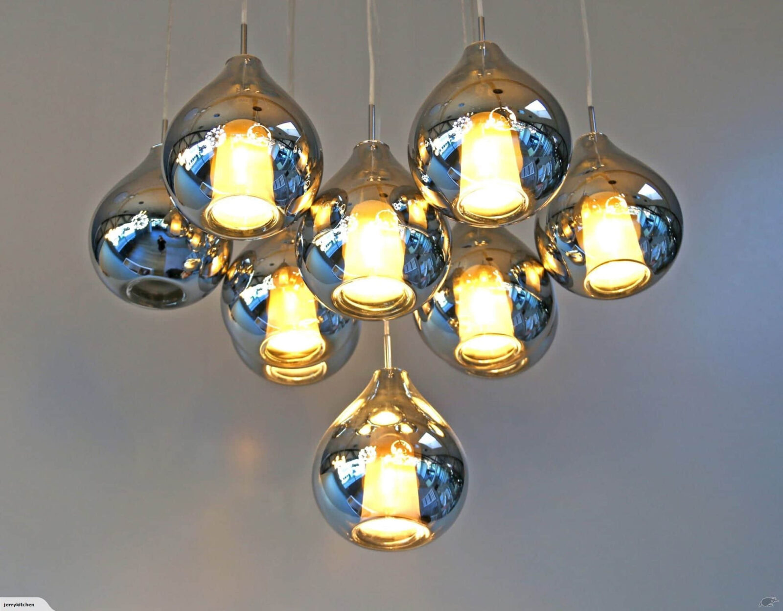 Modern pendant lights with reflective chrome finish and warm glow.