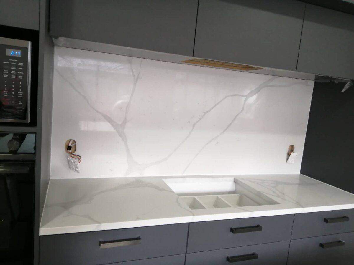 Calacatta Sky Quartz countertop and backsplash in modern kitchen setting.