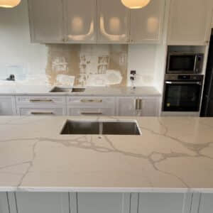 Modern kitchen with Calacatta Sky Quartz countertop and white cabinets.
