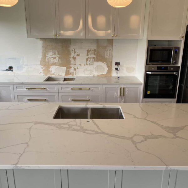 Modern kitchen with Calacatta Sky Quartz countertop and white cabinets.