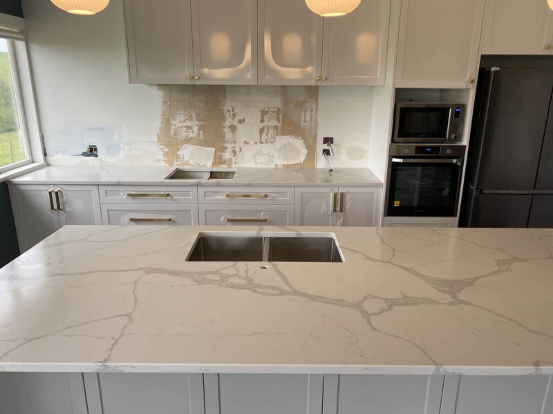 Modern kitchen with Calacatta Sky Quartz countertop and white cabinets.
