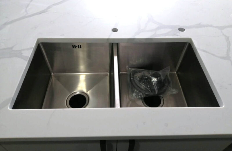 Double stainless steel sink on Calacatta Sky Quartz countertop.