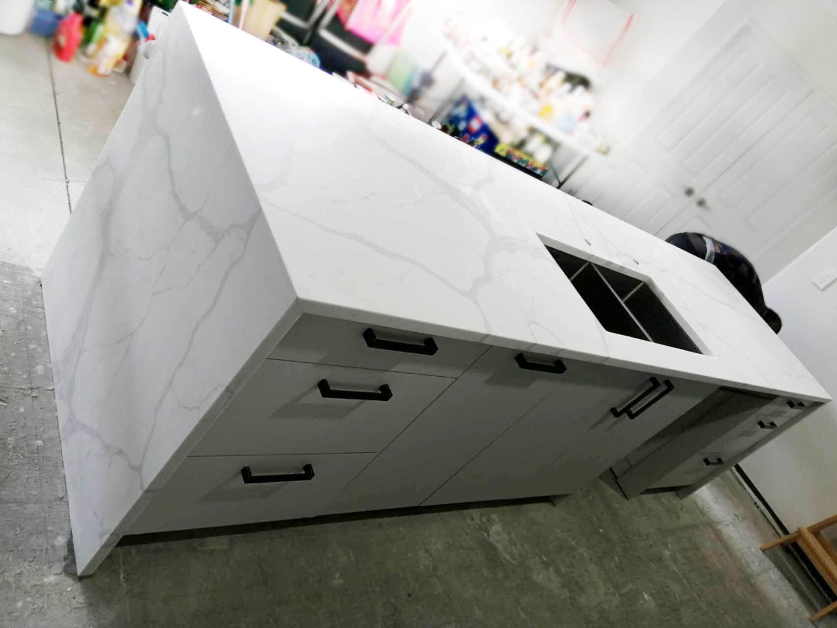 Calacatta Sky Quartz kitchen island with sink and drawers.