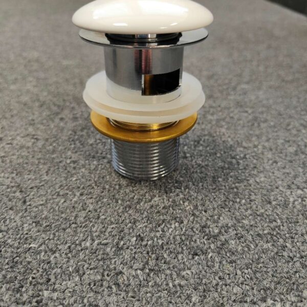 Ceramic pop-up waste on gray surface, Jerry Kitchen product.