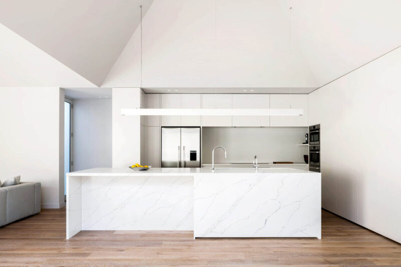 Modern kitchen with white marble island and minimalist design.