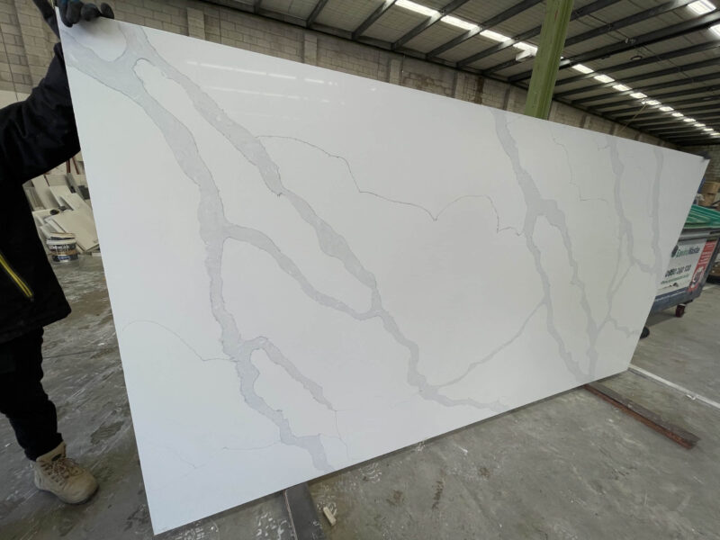 White marble slab with gray veining in a warehouse.