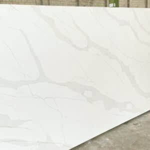 White marble slab with subtle gray veining in a warehouse setting.