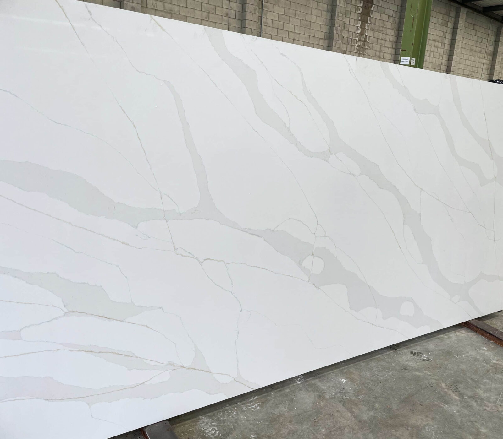 White marble slab with gray veining in a warehouse.